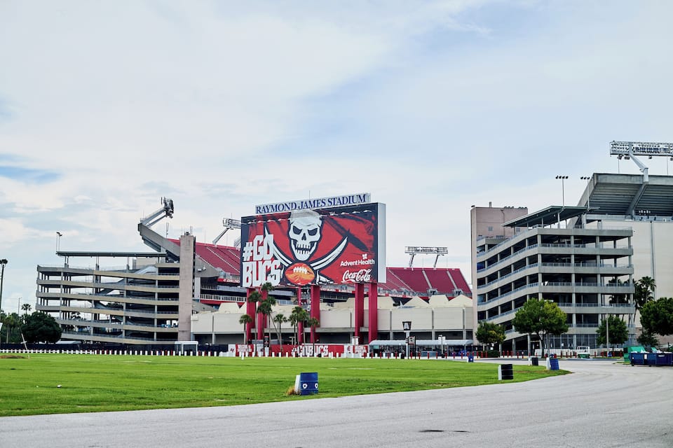 Estadio Raymond James con un anuncio grande y un estacionamiento.