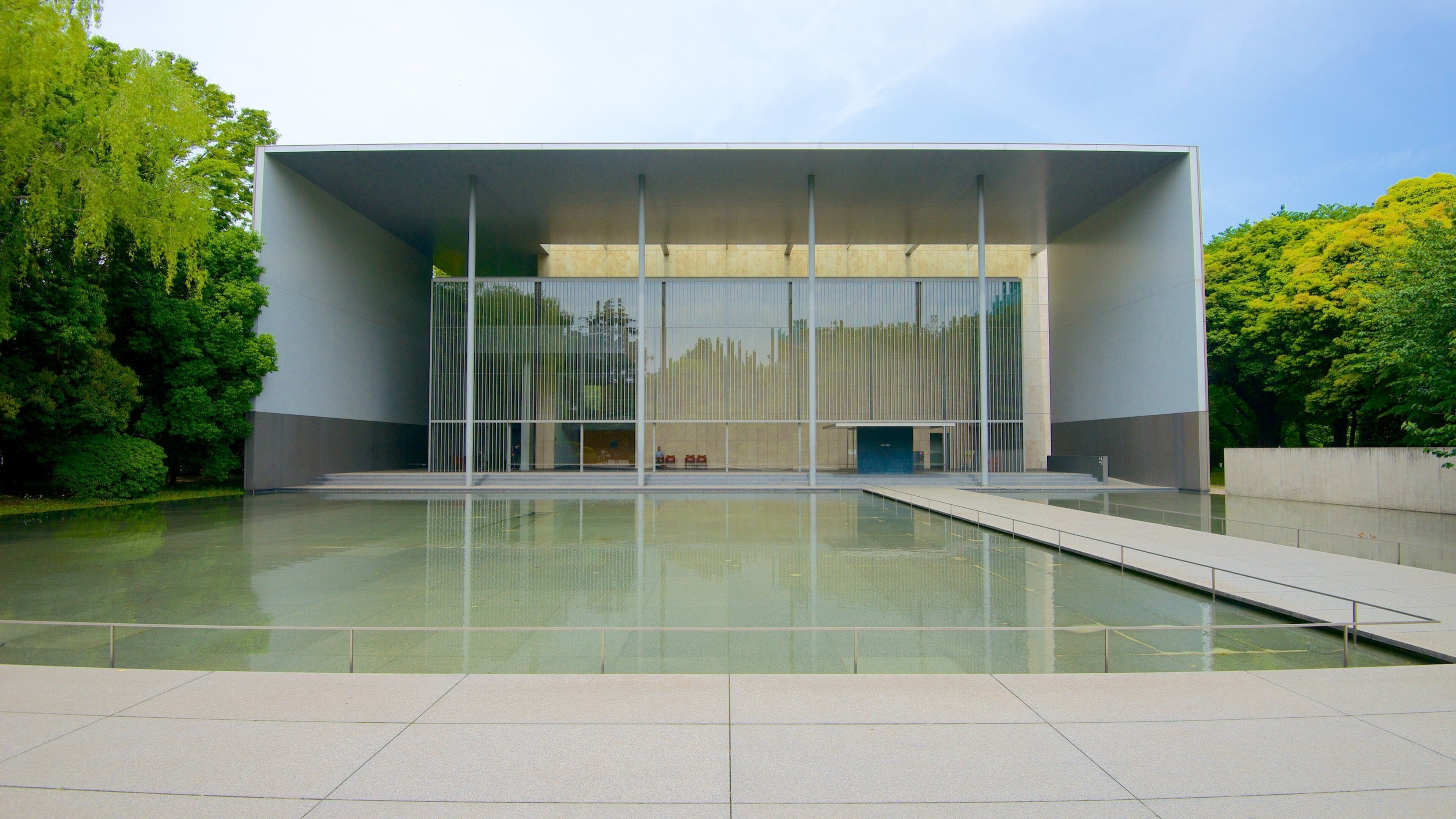 A modern building with a reflective pool in front.