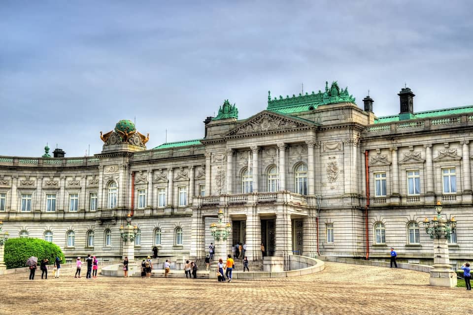 A grand historic building with ornate architecture, a large dome, and a spacious courtyard.