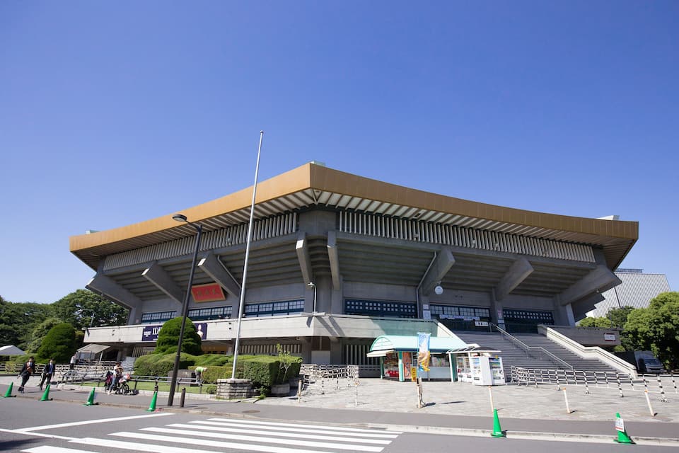 Um estádio grande e moderno com um teto curvo e vários níveis de assentos.