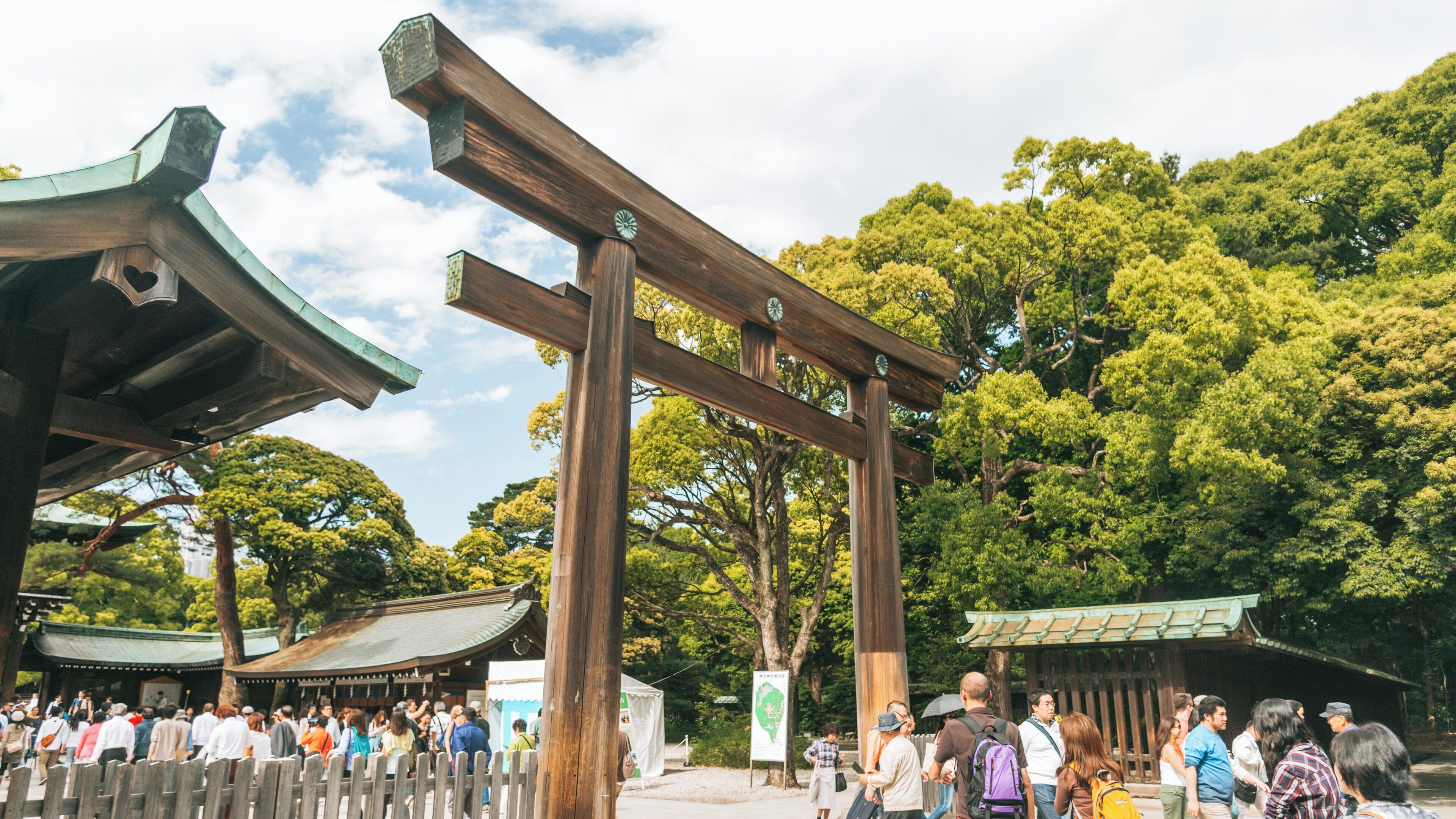 Meiji Jingu Shrine in Shibuya, Tokyo showcases traditional architecture and lush greenery during a busy day of visitors and worshippers