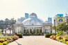 A glass-domed building with a garden in front.