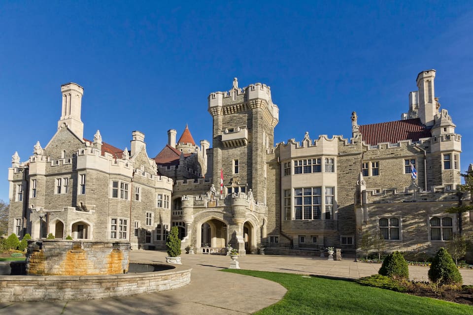 A large stone castle with multiple towers and arched windows.