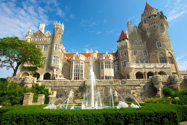 A large castle with a fountain in front.