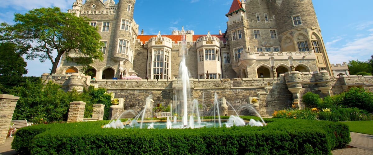 A large castle with a fountain in front.