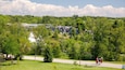 Ein Park mit einer großen Felsformation, Picknicktischen und einem Fußweg.