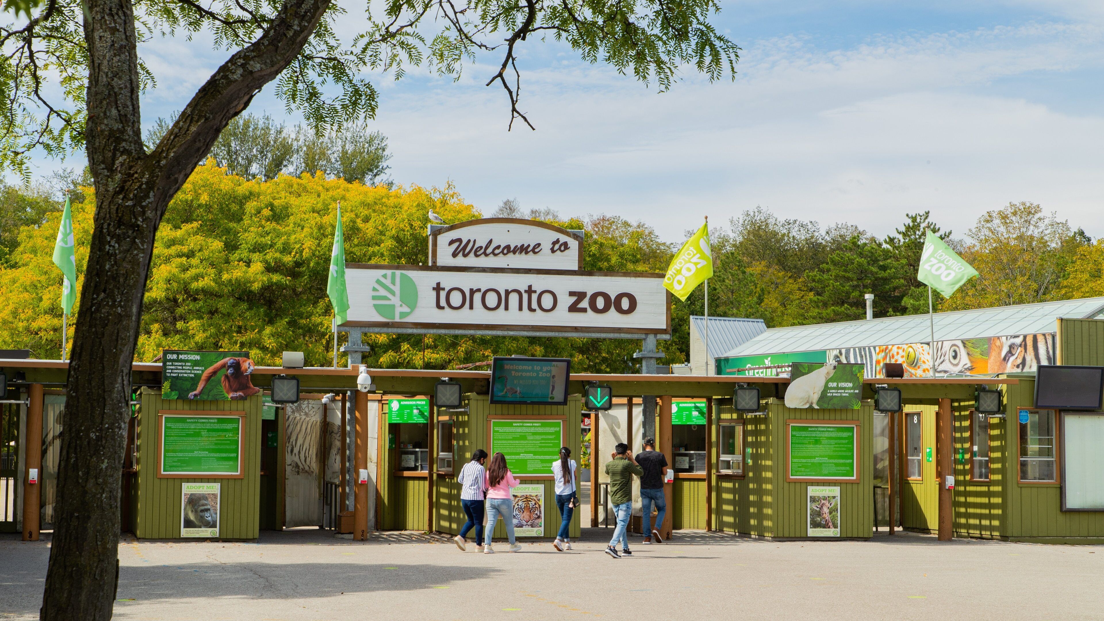 Toronto Zoo featuring zoo animals and signage as well as a small group of people