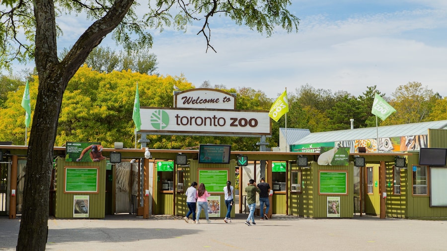 Toronto Zoo featuring zoo animals and signage as well as a small group of people