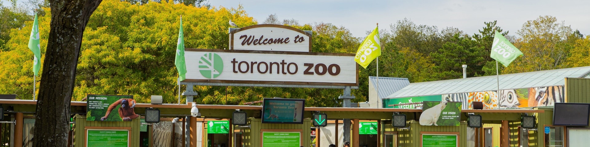 Toronto Zoo featuring zoo animals and signage as well as a small group of people