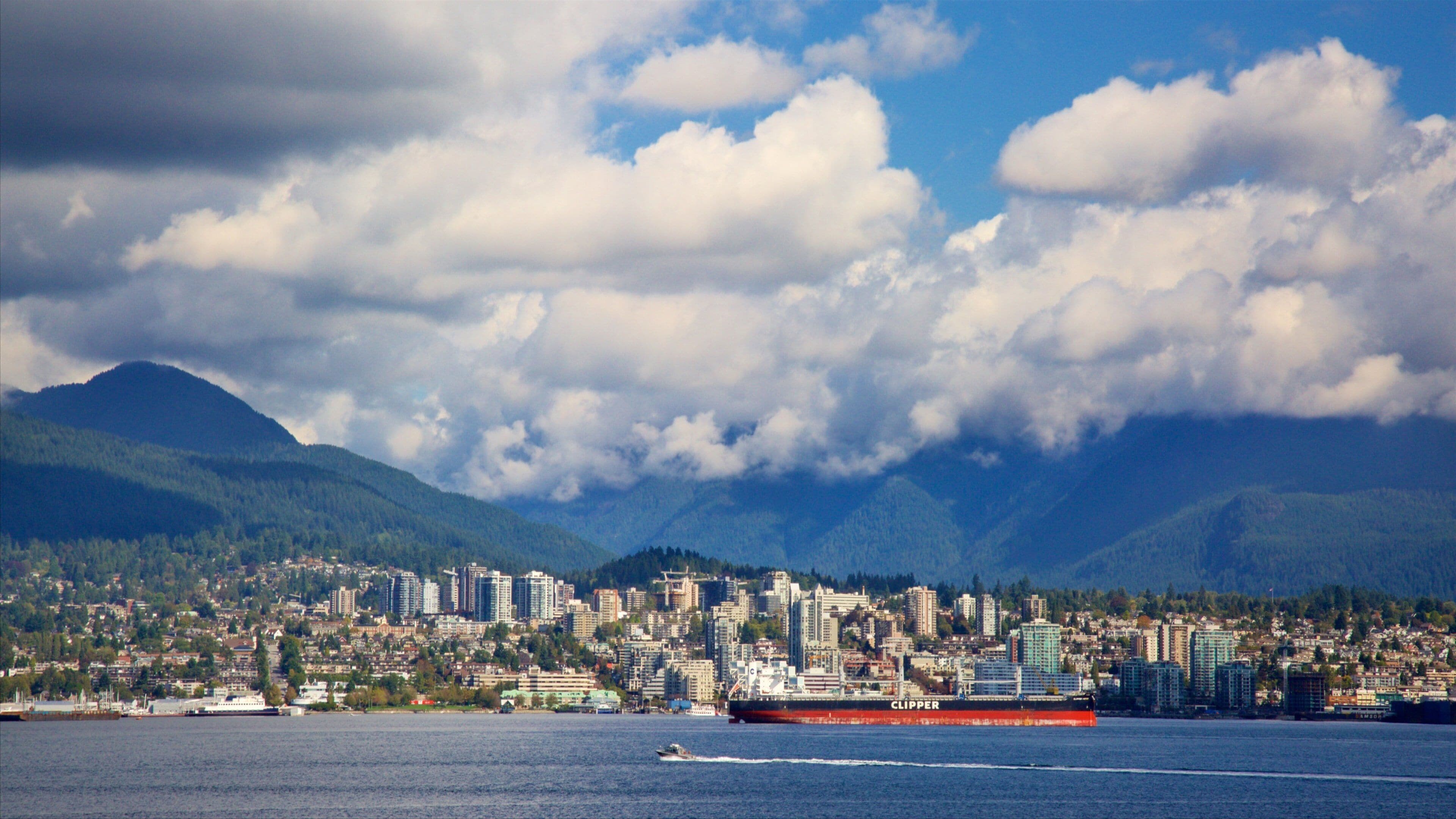 Canada Place which includes a city, mountains and a bay or harbor