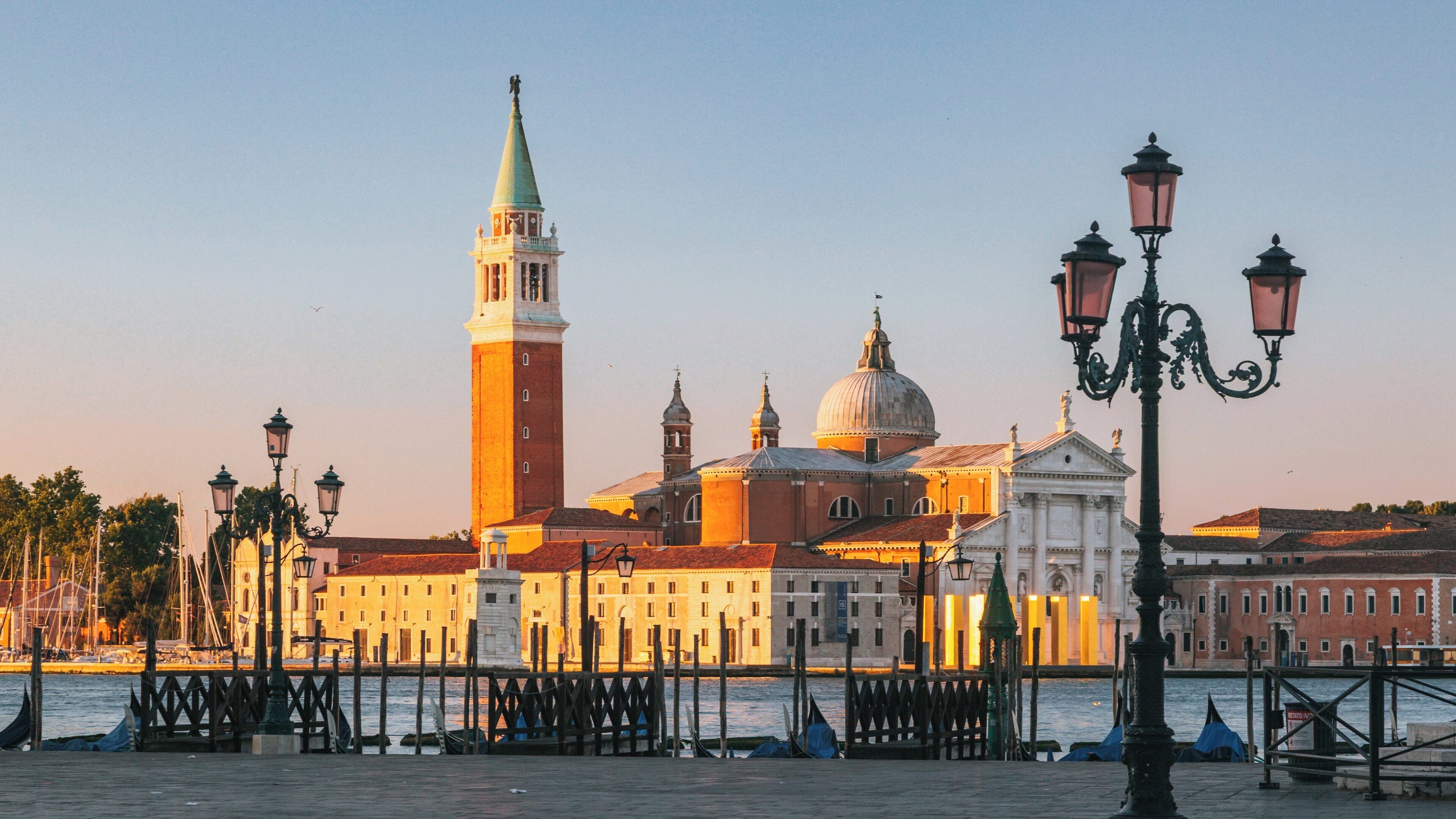 Vibrant sunset illuminates St. Mark's Square in Venice showcasing iconic architecture and serene waterfront views in the heart of the city