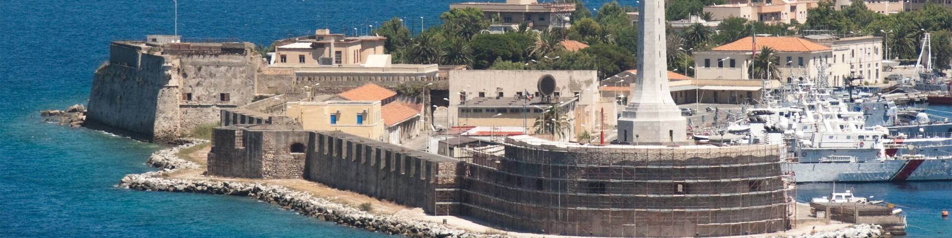 The gold "Madonna della Lettera" statue at the entrance of the Messina's port, Calabria coastline in the background - Italy