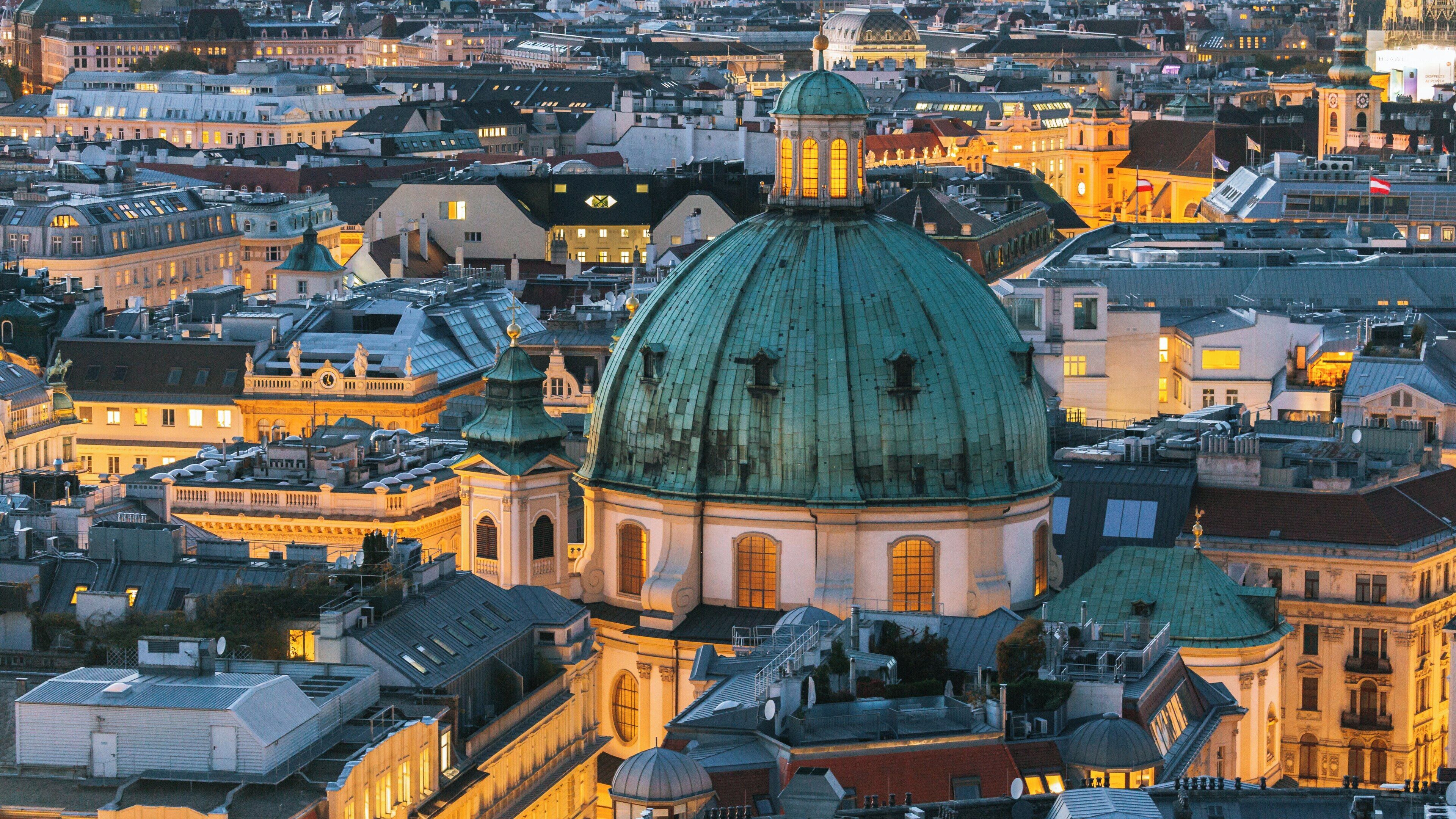 St. Stephen's Cathedral overlooks the historical landscape of Innere Stadt, Vienna, illuminated by the warm glow of evening lights