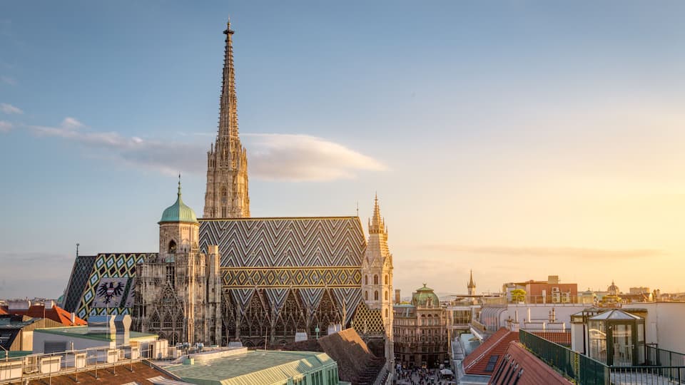A historic cathedral with a tall spire and a large, patterned facade.
