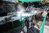 Ein Wasserspiel mit einem Wasserfall, umgeben von Steinmauern und einer Glasschutzwand.