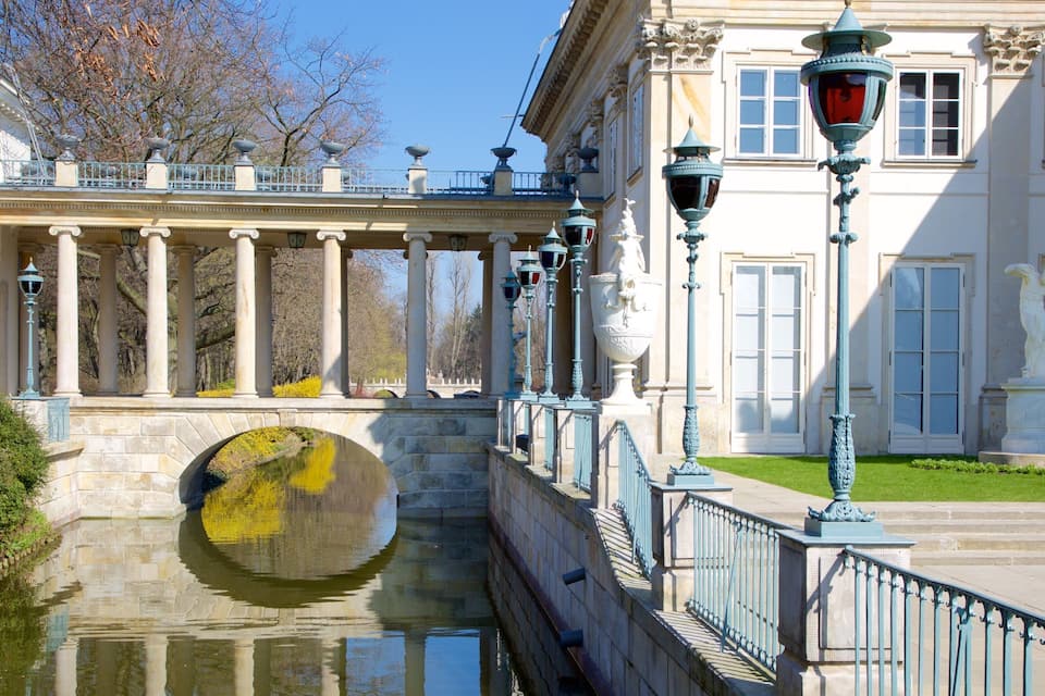 A stone bridge with columns, a canal, and classical architecture.