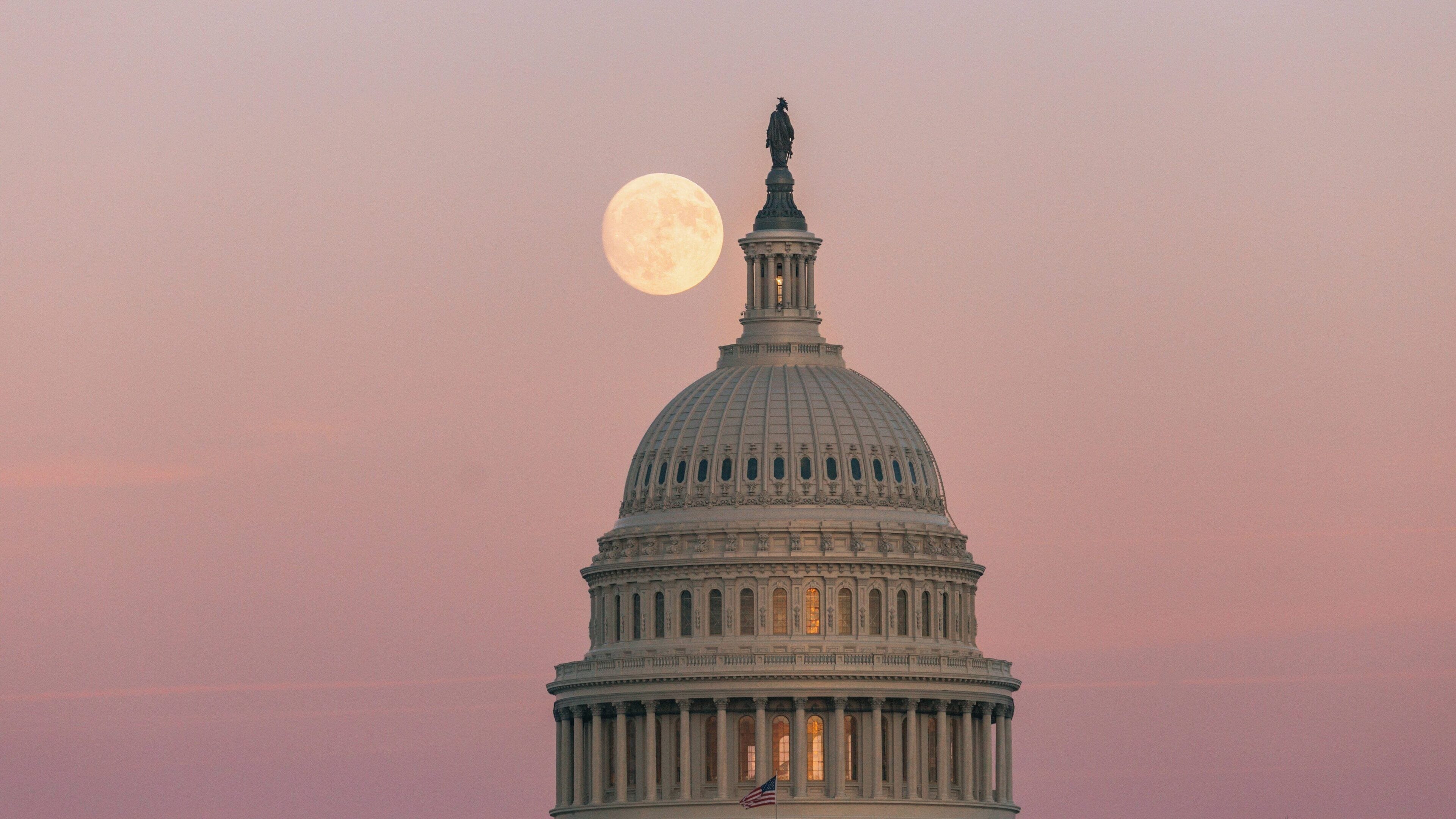 United States Capitol dome illuminated by the moon during twilight in Washington D.C. showcasing iconic architecture and serene atmosphere