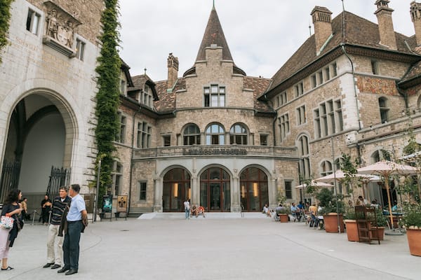 A historic building with a pointed tower, arched windows, and a sign reading "Landesmuseum".