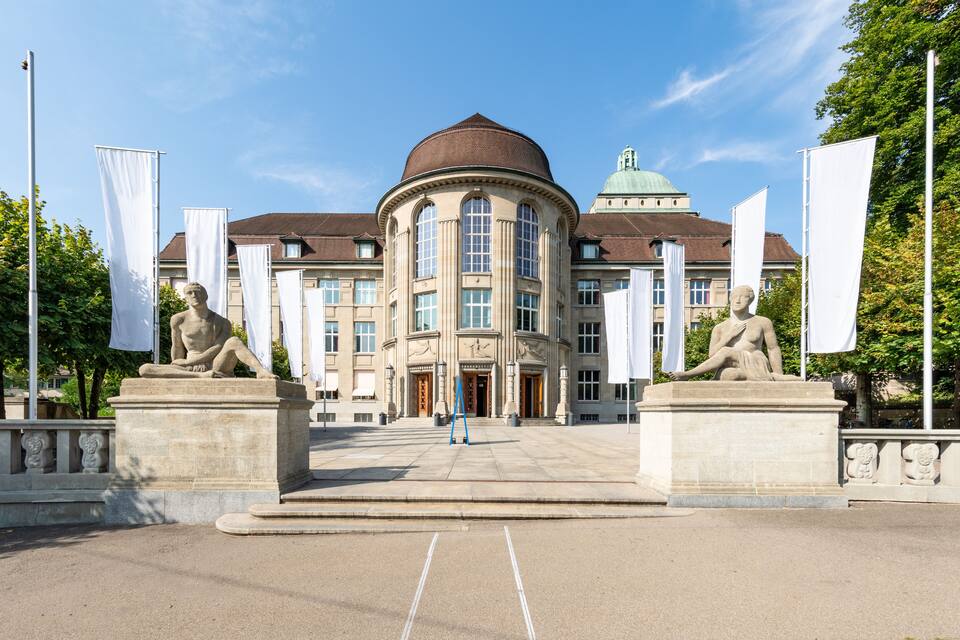 Un bâtiment de style classique, doté d’un dôme et de statues à l’avant.