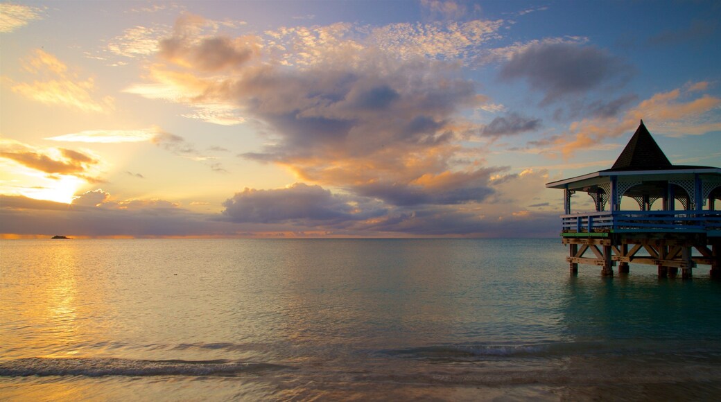 Dickenson Bay Beach which includes general coastal views and a sunset