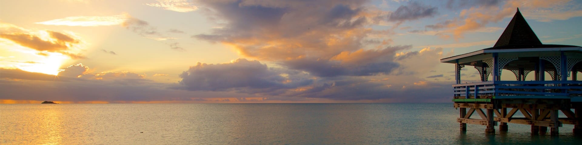 Dickenson Bay Beach featuring a sunset and general coastal views