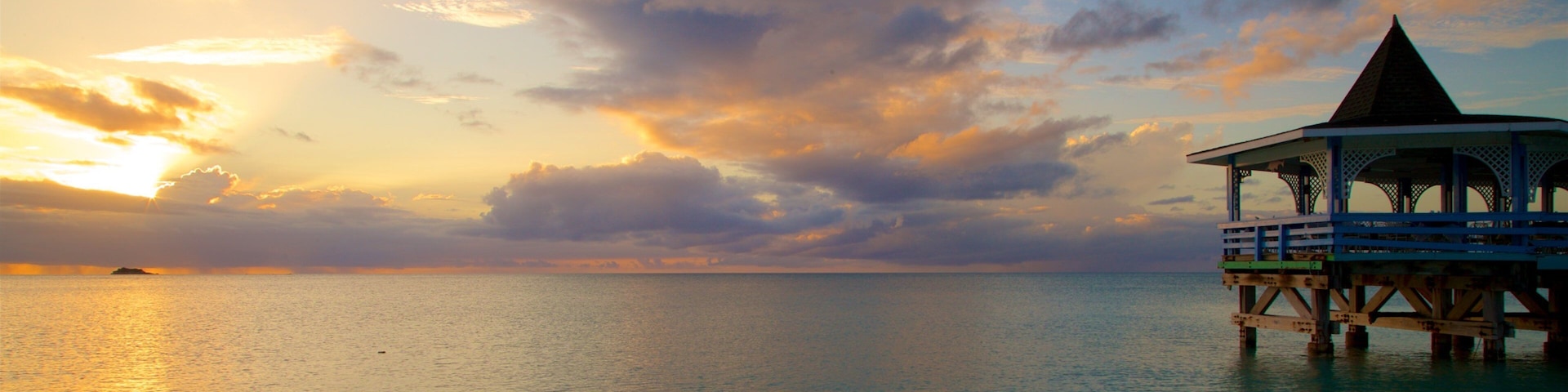 Dickenson Bay Beach featuring a sunset and general coastal views