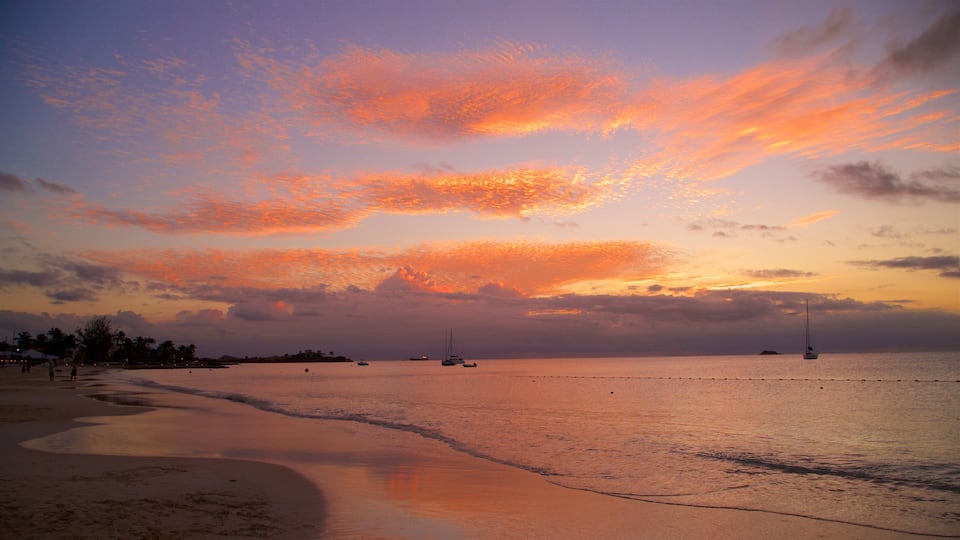 Dickenson Bay Beach which includes general coastal views, a sandy beach and a sunset