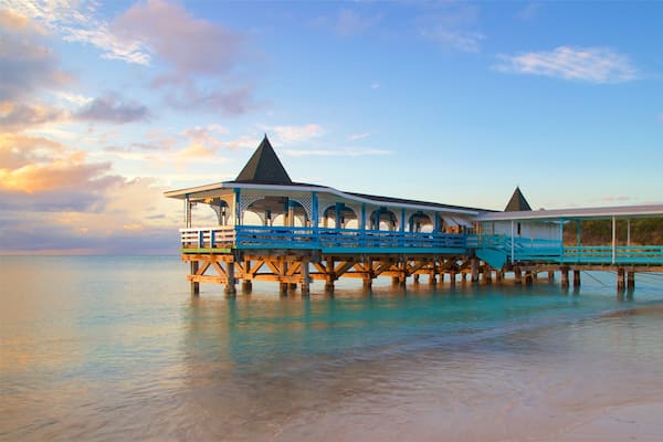 Dickenson Bay Beach featuring a sandy beach, a sunset and general coastal views