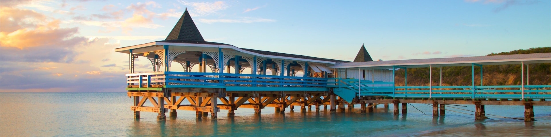 Dickenson Bay Beach featuring a sandy beach, a sunset and general coastal views