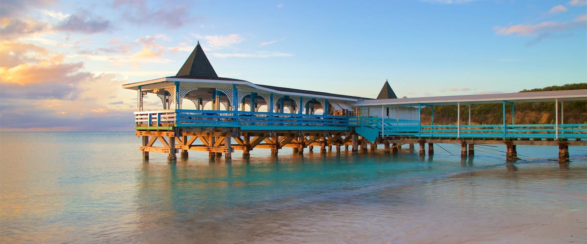 Dickenson Bay Beach featuring a sandy beach, a sunset and general coastal views