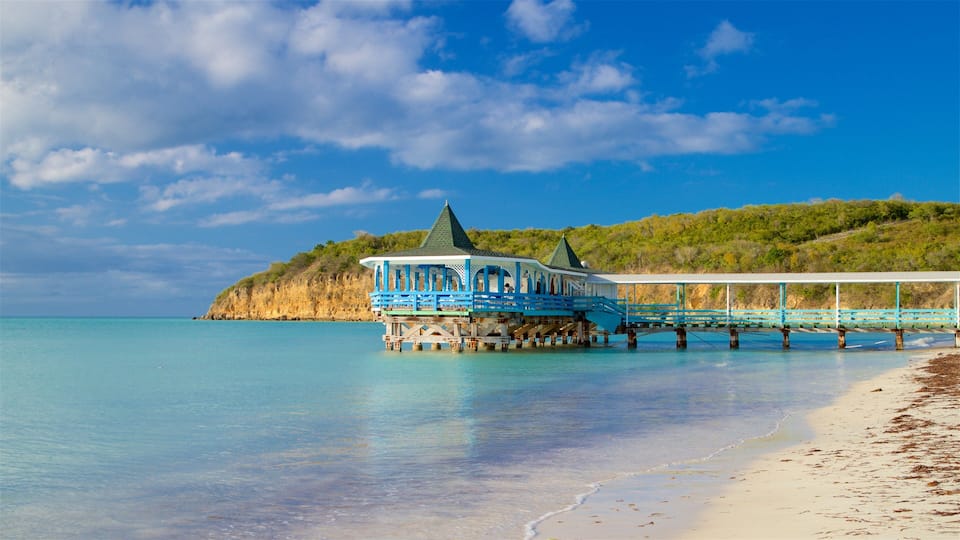 Dickenson Bay Beach which includes rugged coastline, general coastal views and a sandy beach