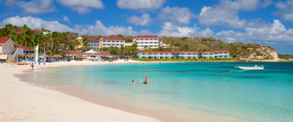 Long Bay que incluye una ciudad costera, natación y escenas tropicales