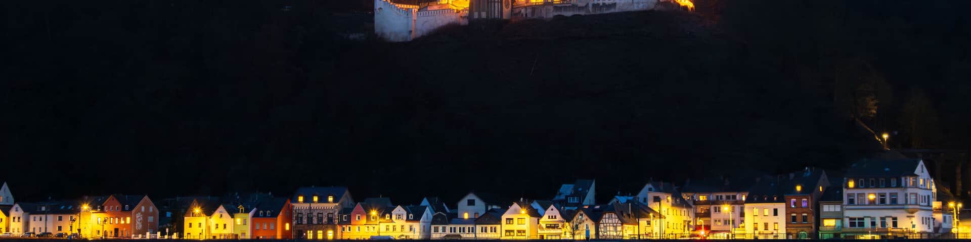 Schloss Stolzenfels am Rhein bei Lahnstein in der Abenddämmerung beleuchtet.