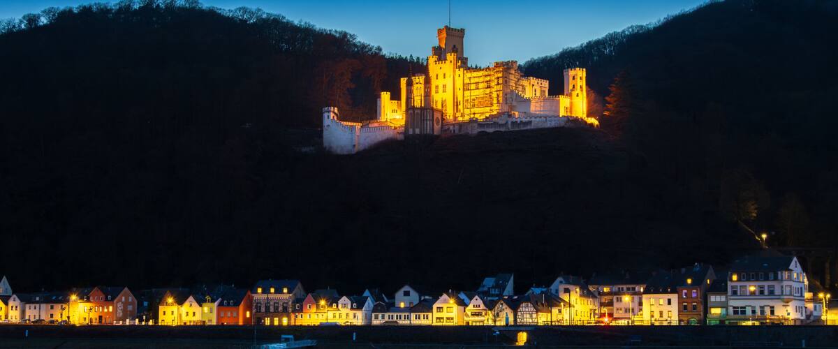 A castle on a hill with a river in the foreground.