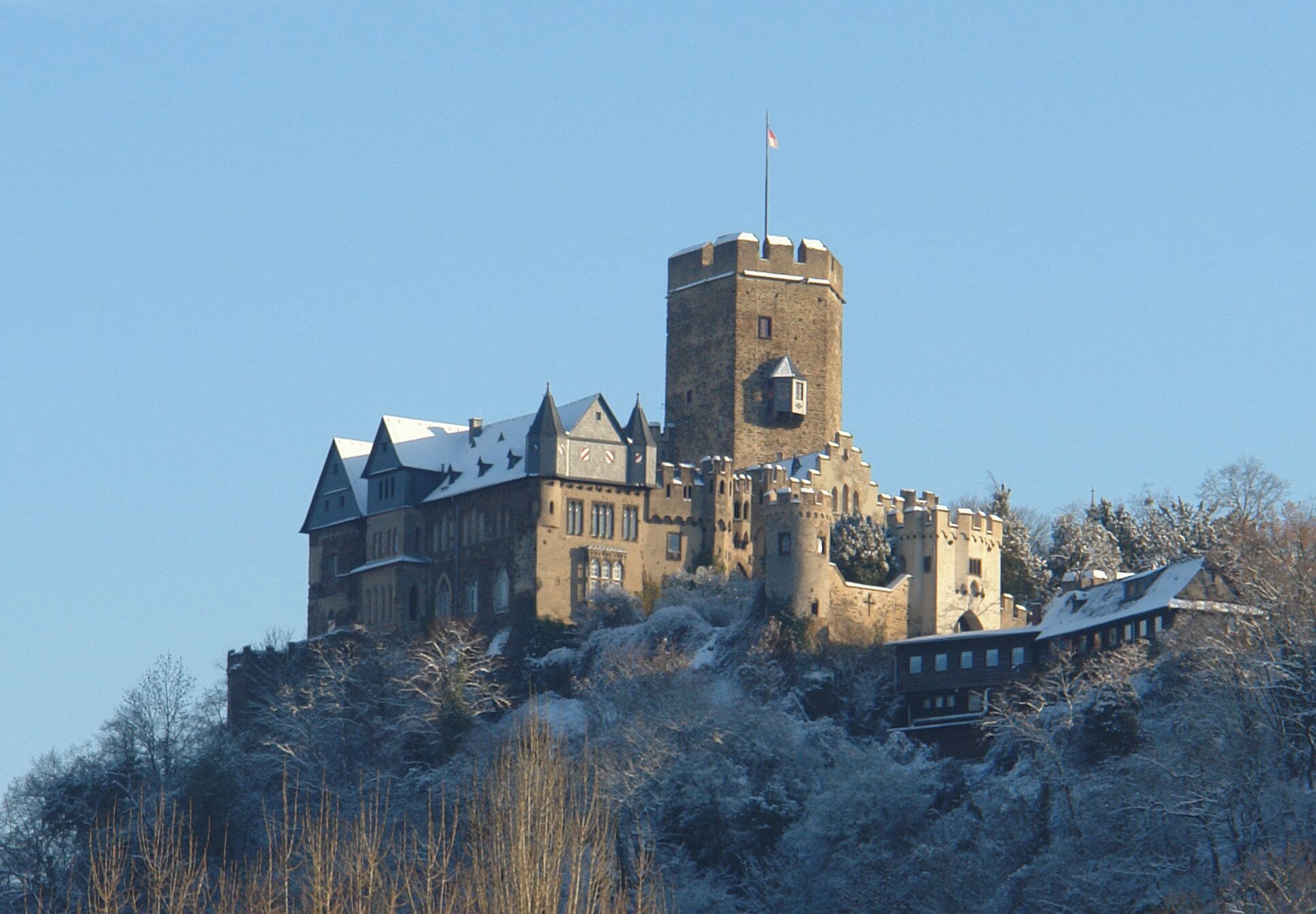 A castle with a tall tower and snow-covered surroundings.