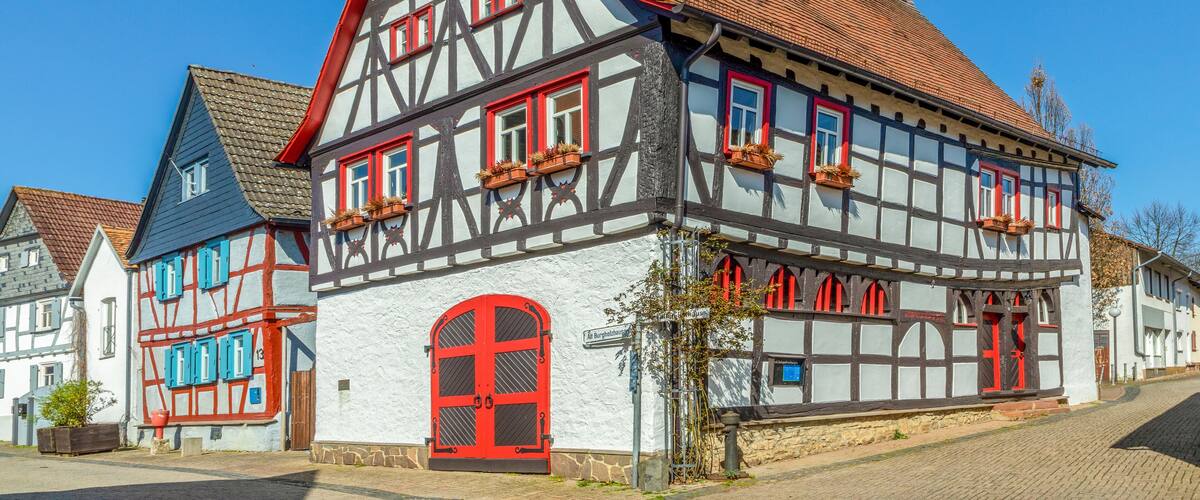 A traditional half-timbered house with red accents and a steeply pitched roof.