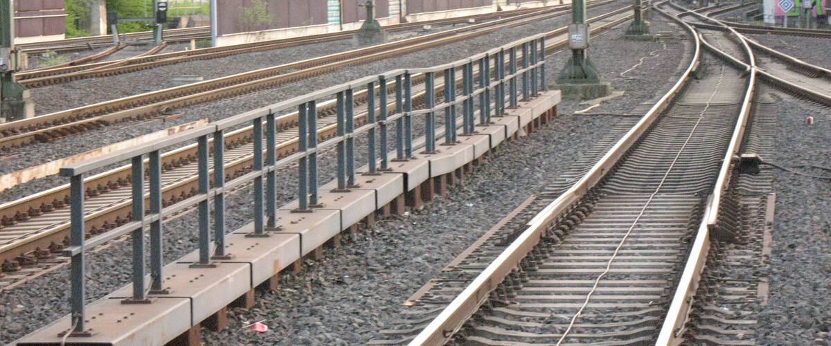 Railway tracks with multiple switches and overhead lines.