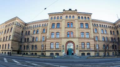 A large, historic building with a symmetrical facade, multiple arched windows, and a central entrance.