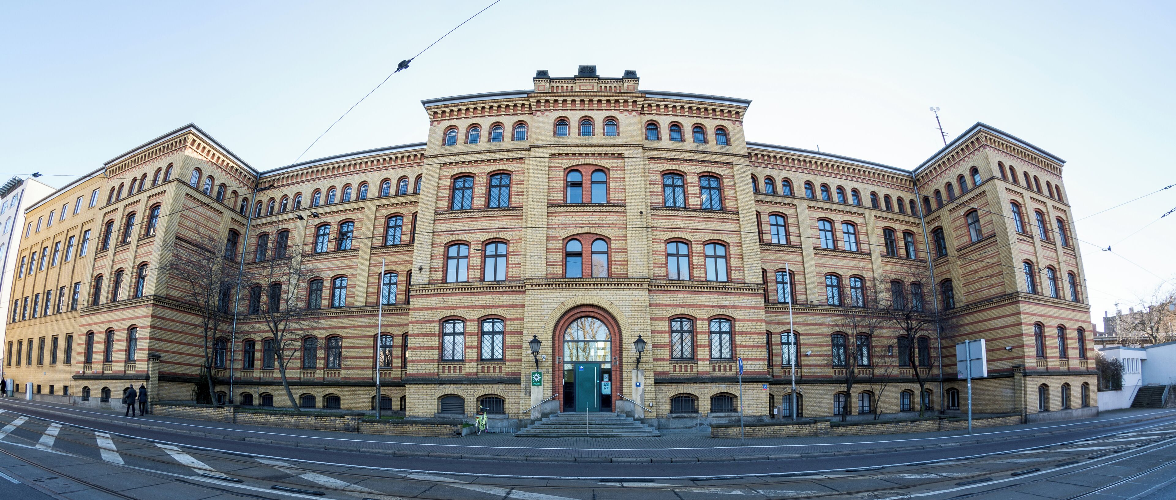 A large, historic building with a symmetrical facade, multiple arched windows, and a central entrance.