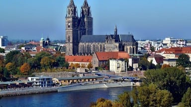 A historic cathedral with twin towers and a river in the foreground.