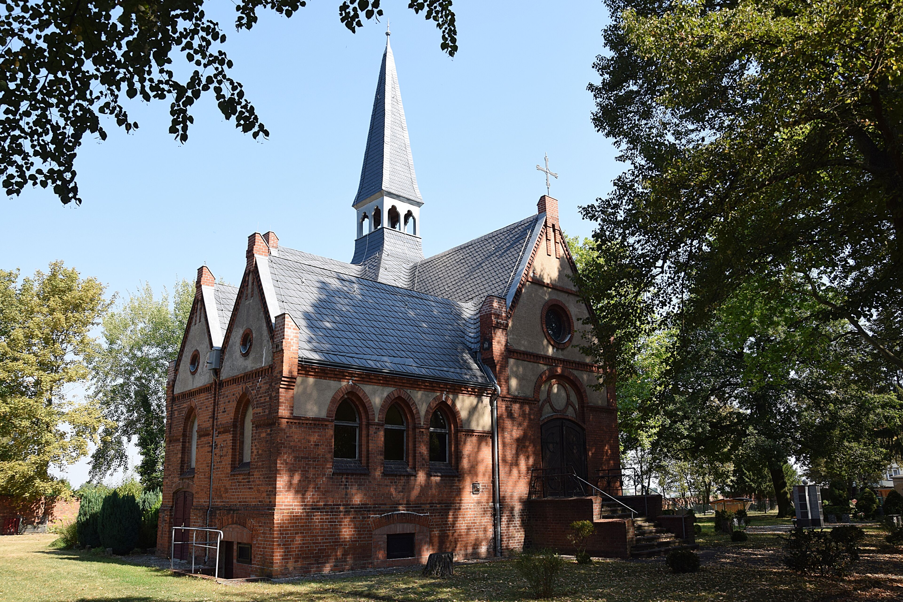 A church with a tall steeple and arched windows.