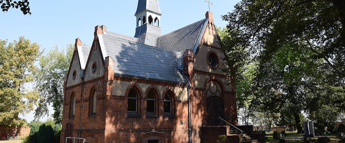 A church with a tall steeple and arched windows.