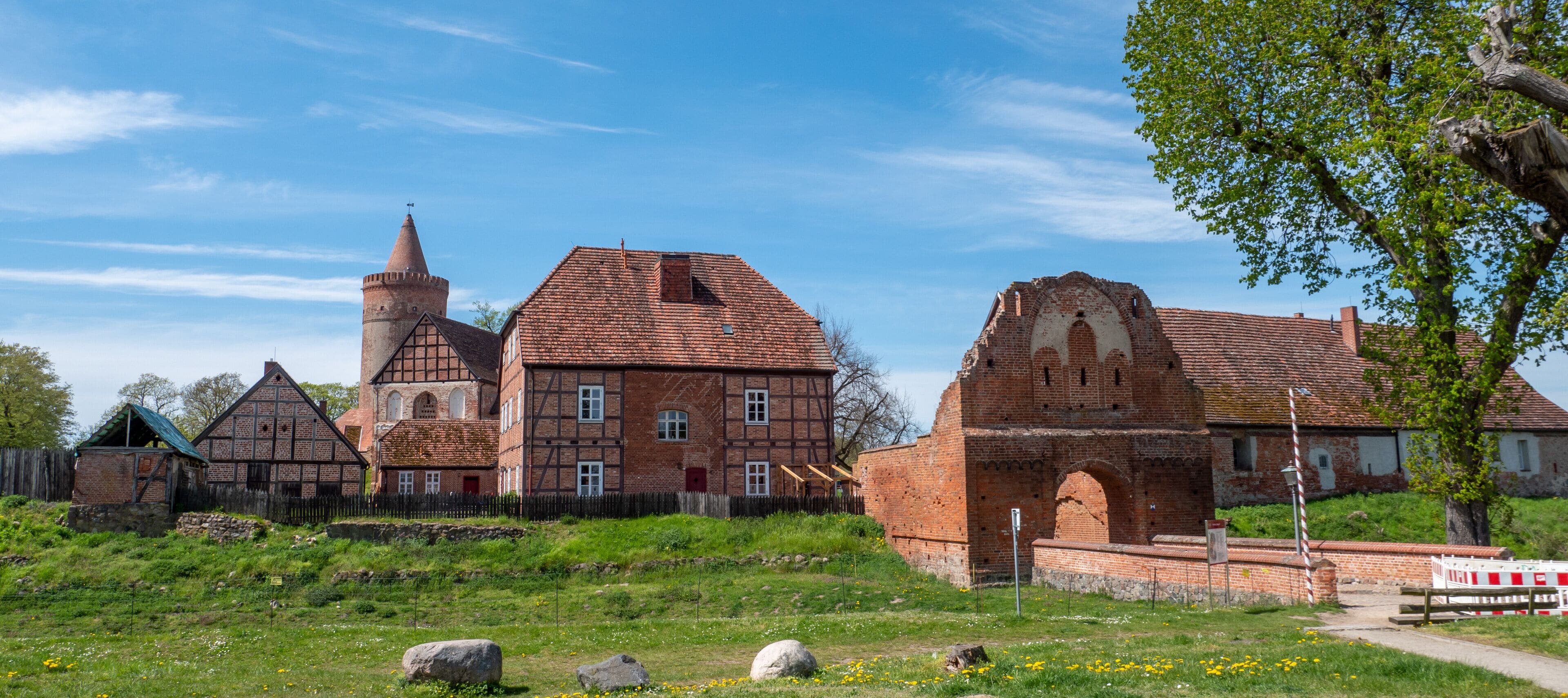 A historic church with a bell tower and a large brick building with a pointed arch.