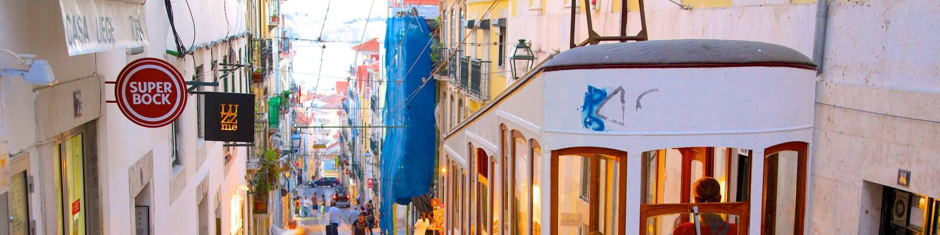 A yellow tram on a narrow street with pedestrians and buildings.