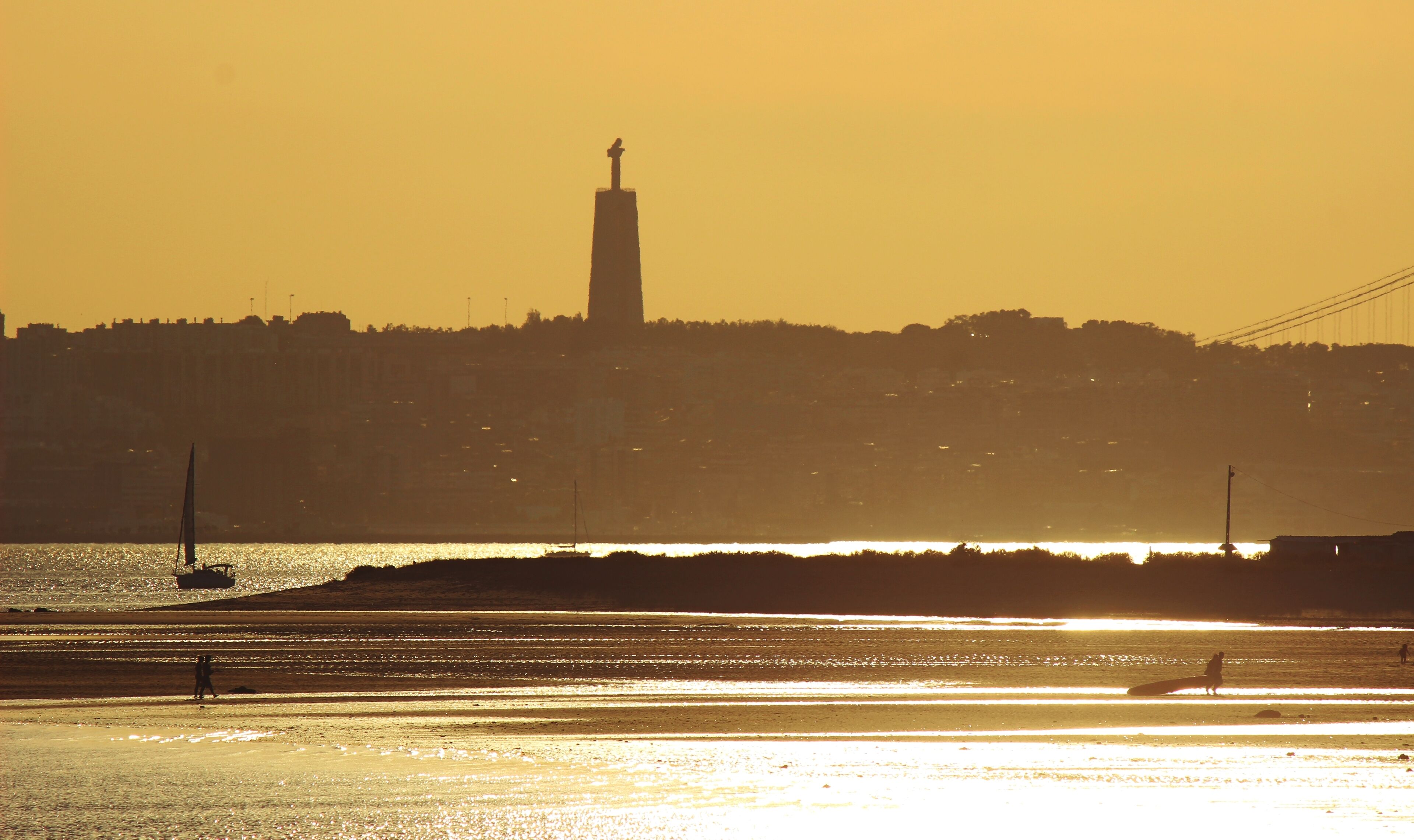 A sunset over a cityscape with a prominent tower silhouette.