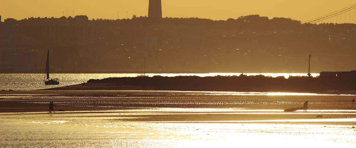 Un atardecer sobre un paisaje urbano con la silueta destacada de una torre.