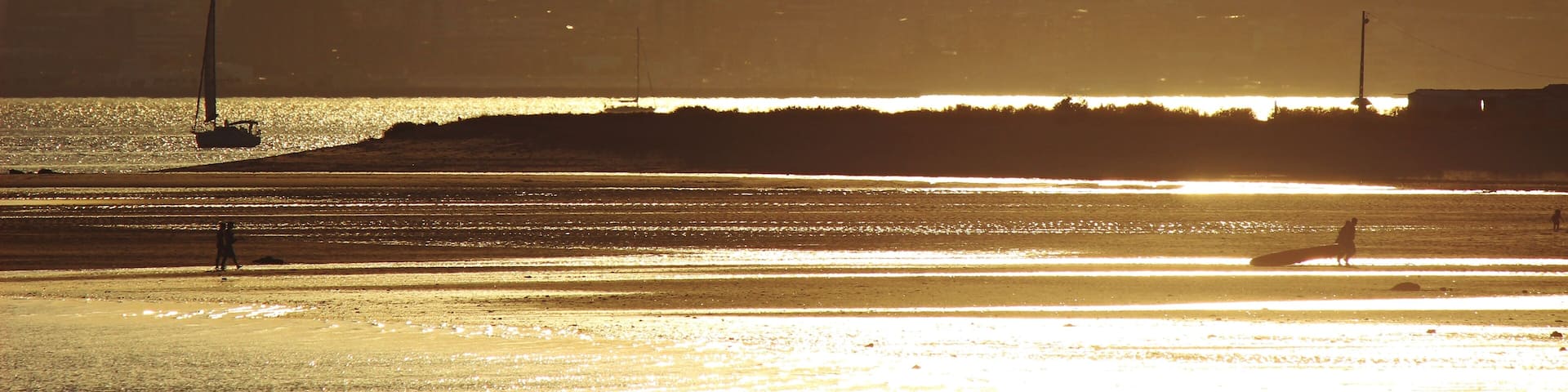 A sunset over a cityscape with a prominent tower silhouette.
