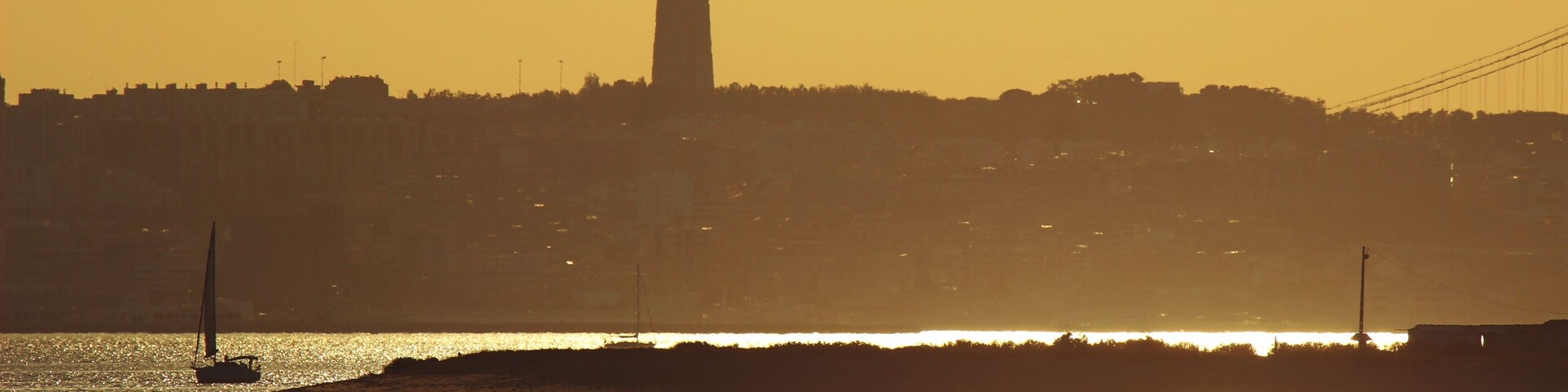 Un atardecer sobre un paisaje urbano con la silueta destacada de una torre.