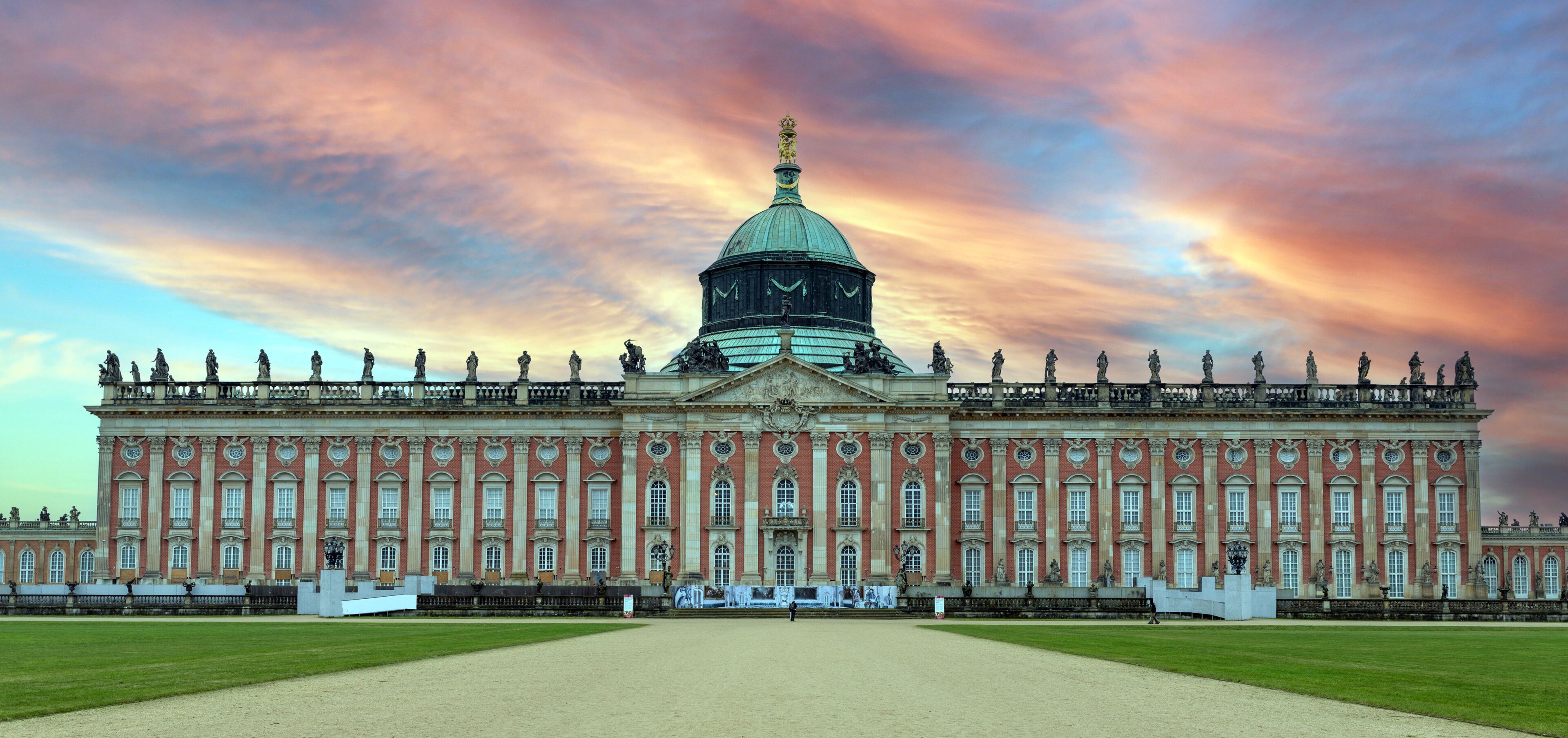 New Palace in Sanssouci Park under dramatic sunset sky in Potsdam, Germany