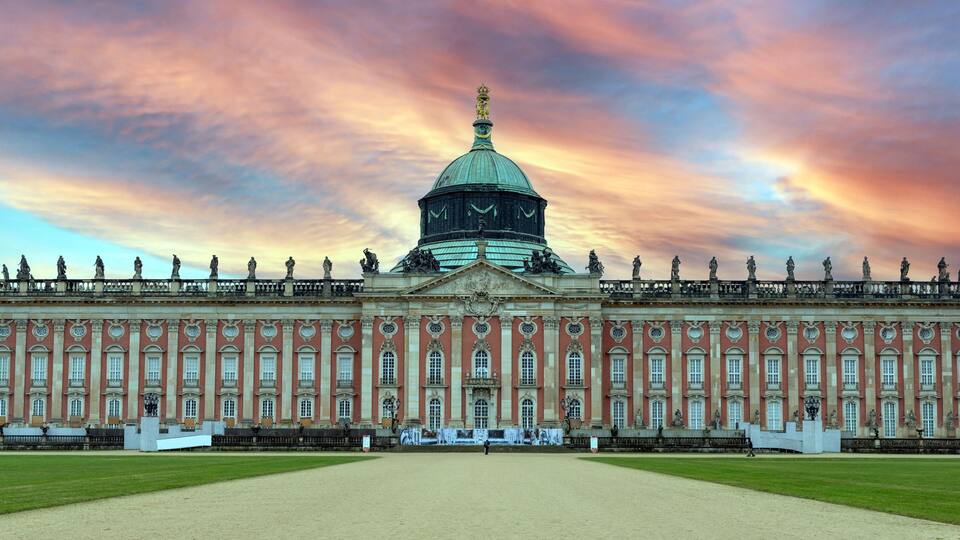 New Palace in Sanssouci Park under dramatic sunset sky in Potsdam, Germany